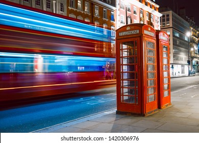 Light trails of a double decker bus next to the iconic telephone booth in London - Powered by Shutterstock