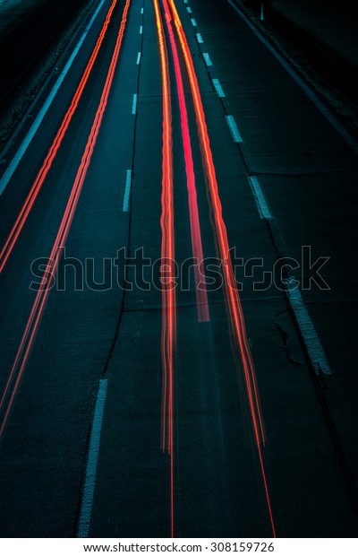 Light trails in a highway seen from the top.\
Converging into the top