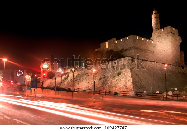 Light trails motion of cars and\
vehicles traffic under Tower of David citadel near Jaffa Gate at\
night in Jerusalem old city, Israel. No people. Copy\
space