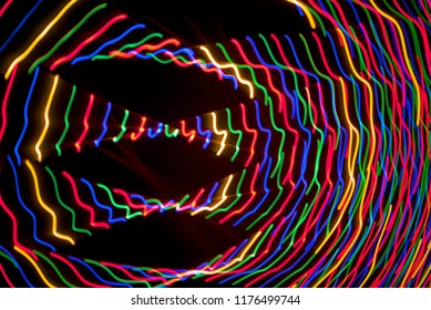 Light trails from moving camera capturing Christmas lights at night.