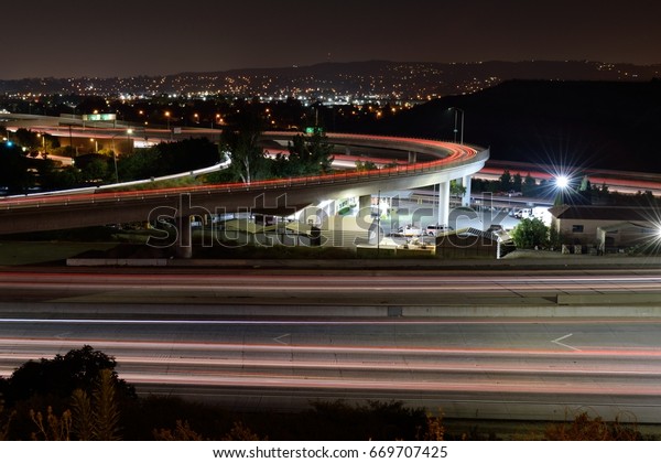 Light Trails on the Freeway: Highway\
traffic appears as red and white streaks of light as it moves north\
and south on a highway in Southern\
California.