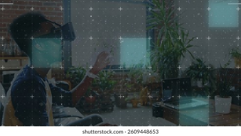 Light trails over grid network against african american man wearing vr headset at office. computer interface and technology concept