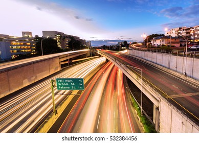 Light trails over H1 highway in downtown Honolulu, Hawaii at sunset golden hour
