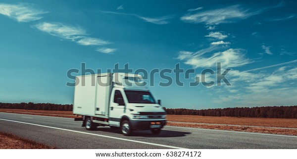 Light truck travel on europe road. Blue sky and\
autumn field panorama.