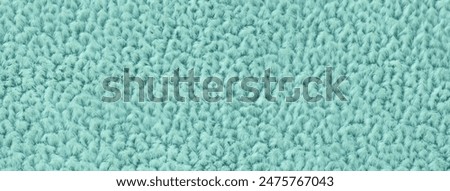 Light turquoise fluffy background of soft, fleecy cloth. Texture of textile closeup.