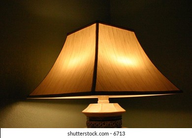 light under lampshade in dimly lit room