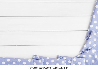 Light violet blue polka dots folded tablecloth over bleached wooden table. Top view image. Copyspace for your text
