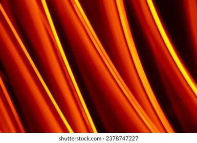 Light wave trail path, vibrant neon gold color in abstract swirls on a black background. Light painting