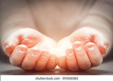 Light in woman's hands. Concepts of sharing, giving, offering, new life
