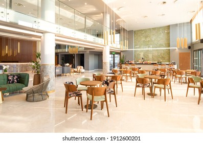 Light wooden and marble tile floor interior of modern cafe with double ceiling height. Lobby bar in luxury design hotel hall with second split level - Shutterstock ID 1912600201