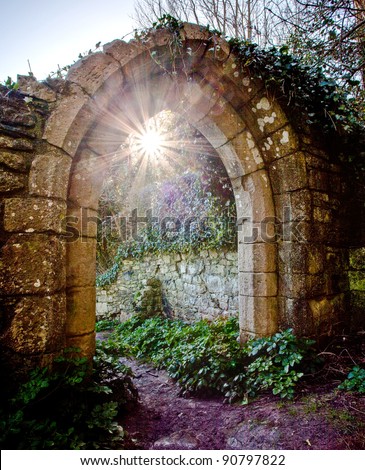 Light of the world - the sun peeps through an old arched doorway at the ruined St Andrew's Church at Church Ope Cove, Portland, Dorset.