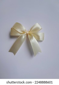 Light yellow ribbon bow made of satin ribbon, ribbon hampers, handmade. Isolated on a white background. - Shutterstock ID 2248888601