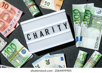 Lightbox board with word CHARITY in black letters around Euro banknotes. Money, Business, finance, investment, saving. Cash bill. Business budget of wealth and prosperity finance