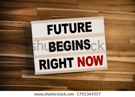 Lightbox or light box with message Future begins right now on wooden table background