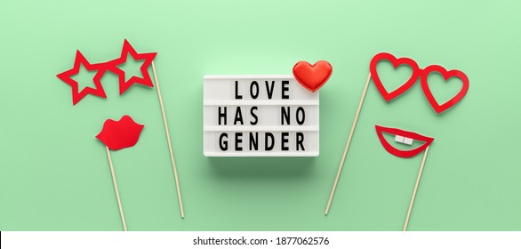 Lightbox with slogan LOVE HAS NO GENDER, red paper props glasses and lips on pastel green ash color background. Concept Homosexuality, lesbian love. Top view, creative flat lay. Holiday Greeting card