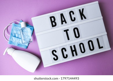 Lightbox with text BACK TO SCHOOL protective face mask and sanitizer. New normal. Social distancing. School quarantine concept. Copy space