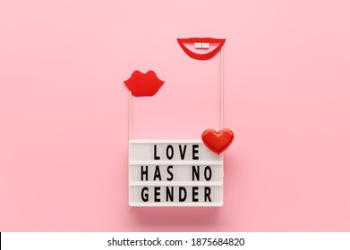 Lightbox with text LOVE HAS NO GENDER, red paper lips props on pastel pink background. Concept Homosexuality, lesbian love. Top view, creative flat lay. Holiday Greeting card