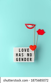 Lightbox with text LOVE HAS NO GENDER, red paper lips props on pastel cyan background. Concept Homosexuality, lesbian love. Top view, creative flat lay. Holiday Greeting card