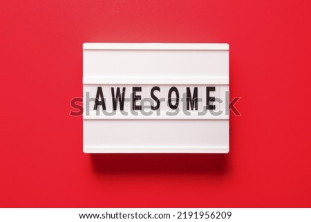 Lightbox with word awesome on red background, top view. Space for text