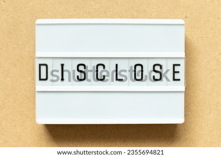 Lightbox with word disclose on wood background