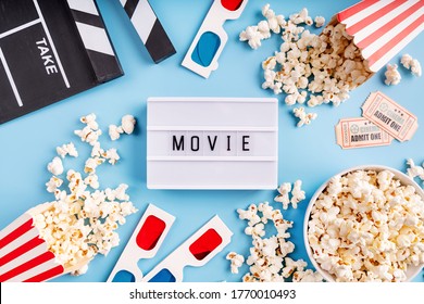 Lightbox With The Word Movie, Popcorn, 3d Glasses And Movie Tickets Top View Flat Lay On Blue Solid Background