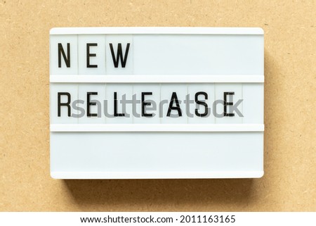 Lightbox with word new release on wood background