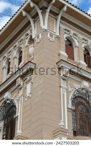 Light-brown painted corner of two-story, fully restored Eclectic-style stately house from the 1930s with Renaissance and Baroque elements in Presidentes avenue, El Vedado neighbourhood. Havana-Cuba.