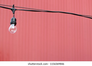 Lightbulb Background Against Red Metal Siding