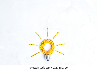 Lightbulb Flat-lay Arrangement Made From A Clothes Drying Cord On A Concrete Background With Copy Space. Creative Thinking To Solve Household Tasks.