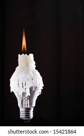 Lightbulb and melted candle wax over bulb. Power and energy saving technology concept. Save the environment isolated on black with copyspace