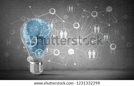 Lightbulb with multiple gears inside placed against social network system on grey wall. 3D rendering.