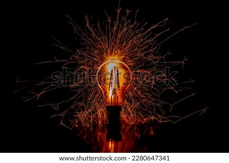 Lightbulb with sparks exploding around. Black background