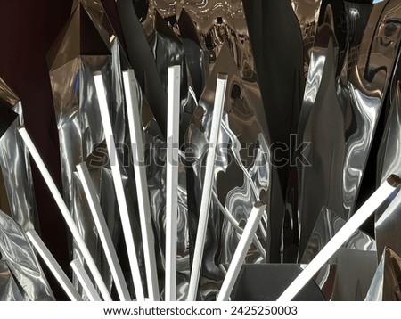 Lighted abstracted peace of art made of metal wavy sheets with long thin lightbulbs. Aluminium foil. Metallic effect background. Artwork isolated. Metal patterns. Lightings abstraction. Futuristic