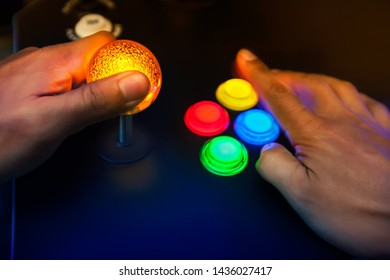 Lighted arcade bubble top joystick and buttons being played by retro gamer.