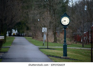 A lighted clock on a bicycle path in Bellville, Ohio. The path goes off in the distance.