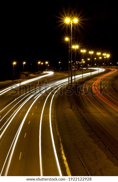 Lighted highway at night with\
cars