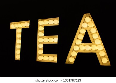 Lighted marquee bulb sign spells "TEA" in a coffee shop. - Powered by Shutterstock