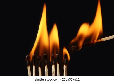 Lighted match next to row of burning matches on black background. Inspiration concept