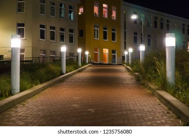 lighted road with lanterns in a city landscape with houses on the background - Powered by Shutterstock