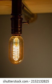 Lighted Vintage Light Bulb In Structure Of Black Iron Pipes