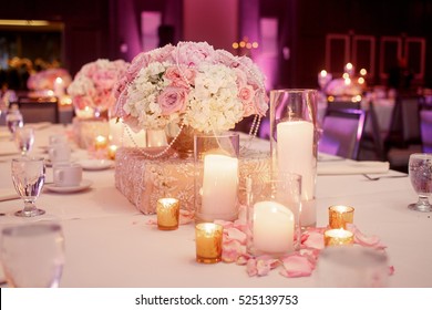 Lighted white candles stand around luxury pink rose bouquet on a table - Powered by Shutterstock