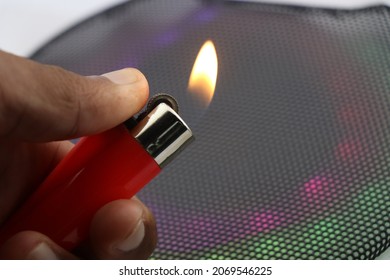 Lighter with fire held in hand with colorful dull lights on a background showing party and celebrations concept