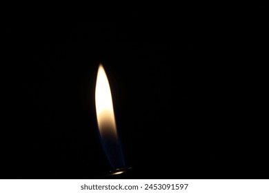 Lighter flame in dark on a black background - Powered by Shutterstock