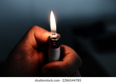 Lighter hand flame in the dark. hope and sadness