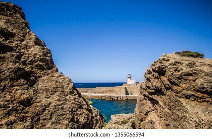 a lighthouse between rocks .