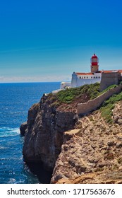 Lighthouse Of Cabo De São Vicente In Sagres. Lighthouse On A Cliff Rock With Blue Sky And Atlantic Ocean In Algarve, Portugal.