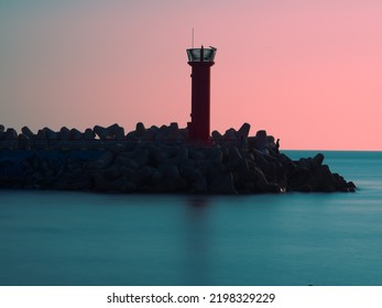 
A Lighthouse In The Calm Sea Above The Breakwater