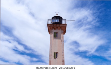 Lighthouse close-up against blue cloudy sky. Camarque Regional Nature Park. France. - Powered by Shutterstock