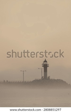 Lighthouse Emerging Through Dense Sea Fog