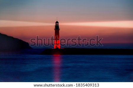 Lighthouse guiding ships at dusk